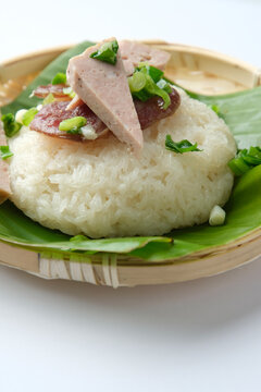 Sticky rice topped with green onions and meatloaf .