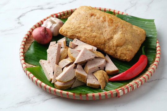 Fried Cha Lua served on a banana leaf inside a woven basket