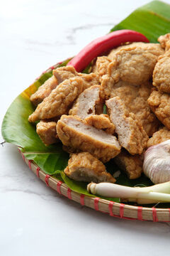 Deep fried Cha Lua slices served on a banana leaf in a woven basket.