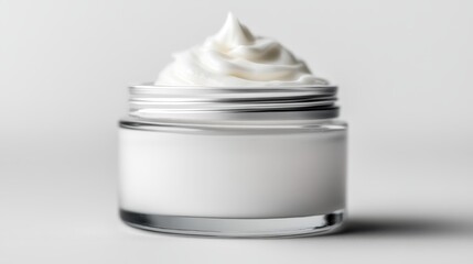  A glass jar, brimming with whipped cream, sits on a pristine white surface The reflection of the jar is visible in its mirror-smooth side