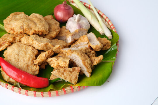 Deep fried Cha Lua slices served on a banana leaf in a woven basket.
