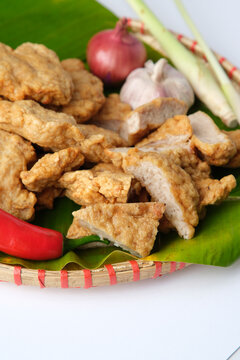 Deep fried Cha Lua slices served on a banana leaf in a woven basket.