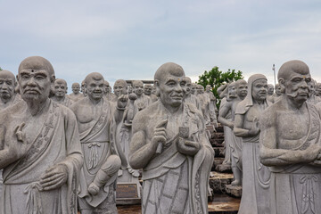 Obraz premium Large group of statues of monks or religious figures arranged in rows in buddhist temple Patung Seribu (Vihara Ksitigarbha Bodhisattva, 500 Lohan Temple) on Bintan Island, Indonesia. Tanjung Pinang