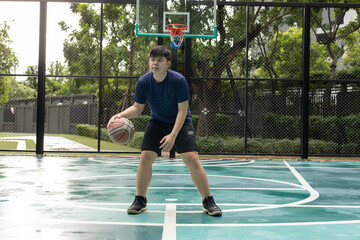Obraz premium A man plays basketball while sitting on the court.