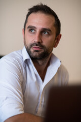 A businessman talking on his smartphone while seated in an office, showcasing his professional demeanor and active communication.