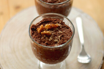Two bowls of chia seed, chocolate and orange pudding. Healthy snack, wooden background. Selective focus.
