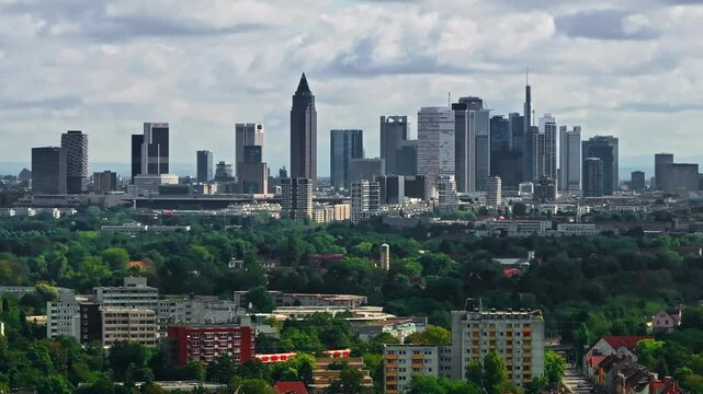 Drone video of Frankfurt's skyline on a partly cloudy day. The footage captures modern skyscrapers, historic buildings, and the dynamic cityscape under a bright, mixed sky. Drone move right