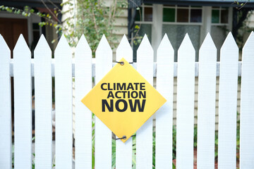 "Climate action now" sign on picket fence