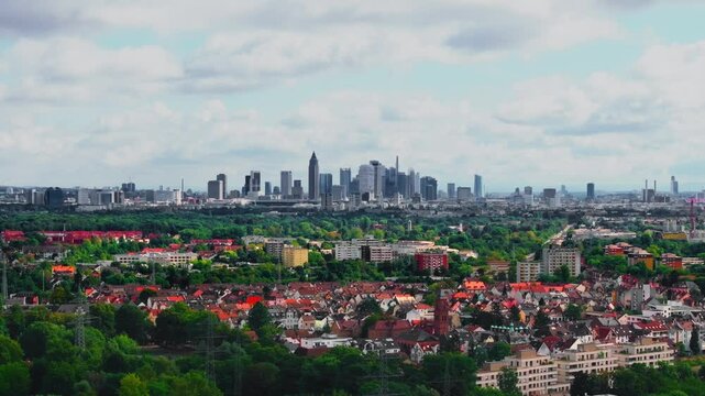 Drone video of Frankfurt's skyline on a partly cloudy day. The footage captures modern skyscrapers, historic buildings, and the dynamic cityscape under a bright, mixed sky. Drone move right