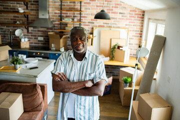 Portrait of a senior black man in apartment filled with moving boxes
