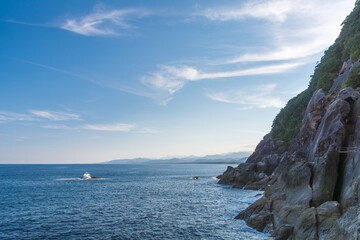 Serene Coastline with Rocky Cliff and Clear Sky