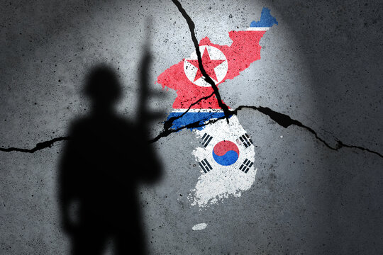Flags of North Korea and South Korean painted on the concrete wall with soldier shadow