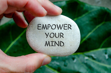 Empower Your Mind text engraved on white stones with leaf background