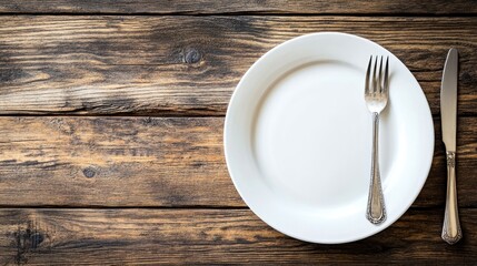 Empty white dish with cutlery on a wooden surface