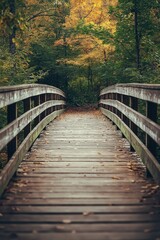 Obraz premium A rustic wooden bridge arcs through a vividly colorful autumn forest, inviting exploration and reflection in nature.
