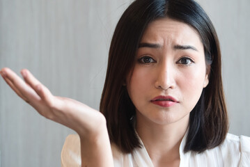 Angry Asian woman shrugging with irritating expression, upset unhappy young adult real woman...