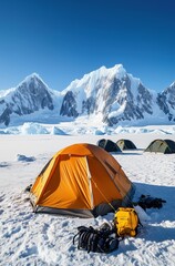 A yellow tent is set up in the snow next to a backpack