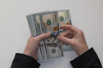 Woman hands holding pile of 100 US dollar banknotes
