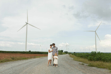 Obraz premium Family is standing blowing looking soap bubbles couple of daughter relaxing windmill rice field windmill, In concept clean energy, natural energy,