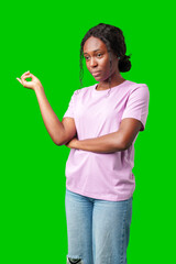 Young woman with curly hair shows a skeptical expression against a bright green background