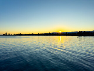 Issyk-Kul Lake with a cloudy sky and mountains in the background. The water is calm, reflecting the...