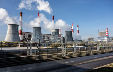 Smoking pipes of power plants against the blue sky. Puffs of steam over cooling towers.