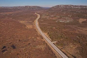 Aerial view of Bugoyfjordveien E6 asphalt road in sunny summer weather, Norway.