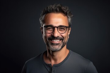 Fototapeta premium Man with glasses is smiling and wearing a black shirt. Concept of happiness and contentment