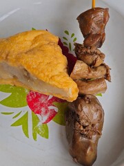 Side dish of tofu stuffed with meatball (tahu bakso), deep-fried to golden perfection, served with sweet marinated chicken liver and gizzard skewers (sate ati ampela bacem).