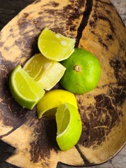 Slices of lime (Citrus aurantiifolia) in a coconut shell dish, commonly served with Indonesian soto. Adds a fresh, tangy flavor to enhance the taste of the meal.