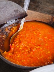 Bright orange chili sauce made from blended red and orange chilies with added water, commonly served with Indonesian dishes like soto or bakso. Spicy, vibrant, and flavorful.