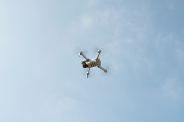 The drone flies against the blue sky