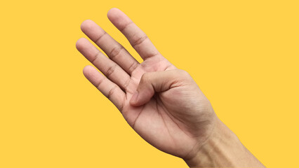 Man's hand showing four fingers raised on a yellow background, signaling for help or indicating...