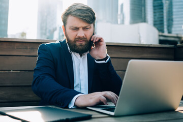 Serious man speaking on smartphone