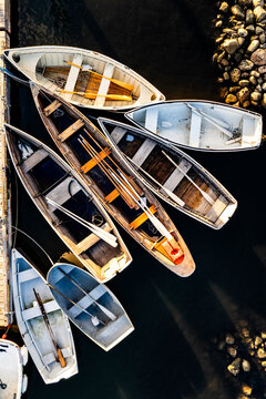 Vertical top-down view of wooden rowing dinghies tied together at a float, Center Harbor, Brooklin, Maine