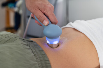 Physical therapist uses ultrasound therapy on a patients lower back to relieve pain and promote...