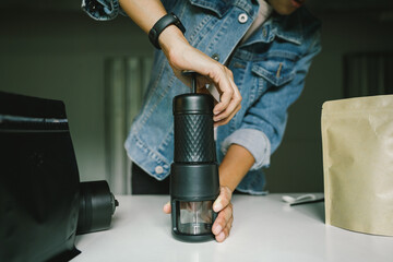 Preparing coffee man pressing the Manual pressure pump of a portable mini coffee maker to get a shot of espresso, Home coffee