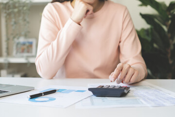Deduction planning concept. Asian young woman hand using calculator to calculating balance prepare...