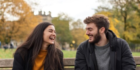 Obraz premium Happy couple laughing together in a park during autumn.