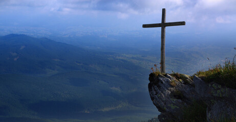 Wooden cross on a mountain against the sky. Biblical scene, concept of Holy Scriptures of Old and New Testaments, Christian religion