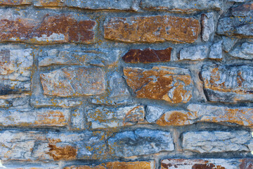 Fototapeta premium full frame old stone wall with neutral brown tones rough texture background