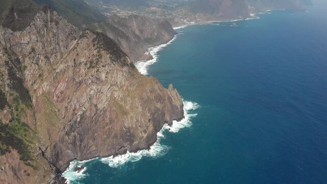Vereda do Larano coastal hike along ocean cliffs on Madeira Island Portugal. Cinematic, aerial drone shot, 4K. High angle, tilting.