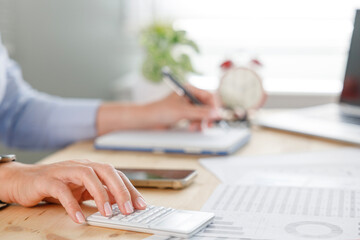 Businesswoman calculating income and balance using calculator