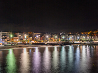 Fototapeta premium Blanes on the Costa Brava night photography, reflections of lights in the Mediterranean Sea if dark night