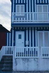 Blue and White Striped Building with Picket Fence