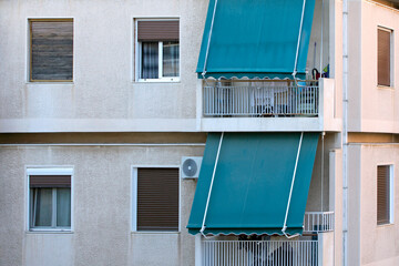 close up on the facade of an apartment building in Athens, Greece with green awnings. sunny day