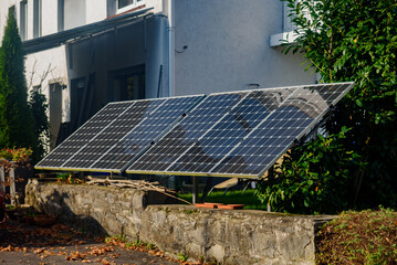 Solar panels, mounted on the ground in the yard of  residential home. Solar panels positioned on...