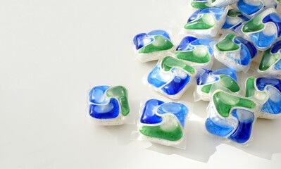 Multi-colored capsules for dishwashers on a white background.