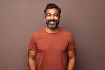 Obraz premium Portrait of a satisfied indian man in his 30s donning a trendy cropped top on solid color backdrop