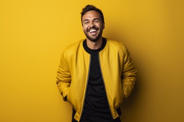 Fototapeta premium Portrait of a cheerful man in his 30s wearing a trendy bomber jacket while standing against solid color backdrop